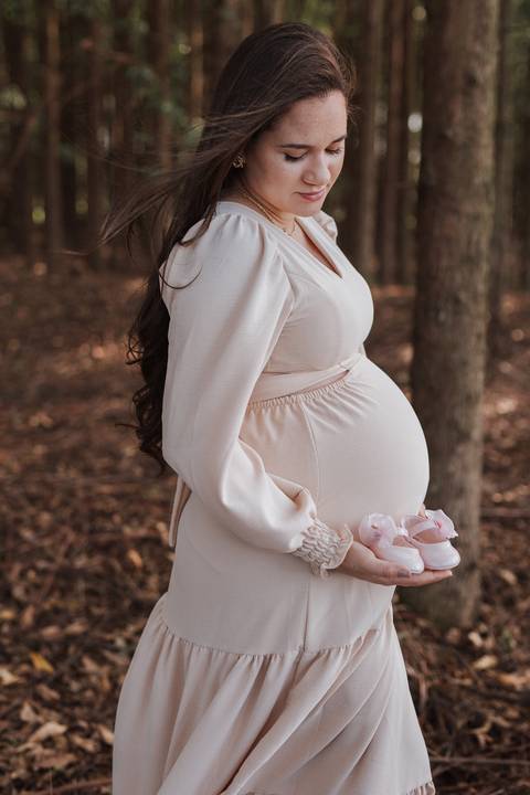 foto com sapatinho de bebe em ensaio gestante'