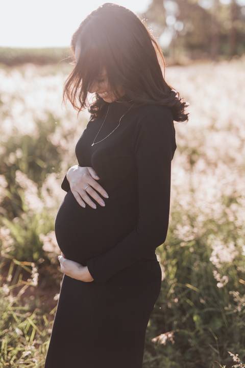 ensaio de gestante no campo com por do sol'