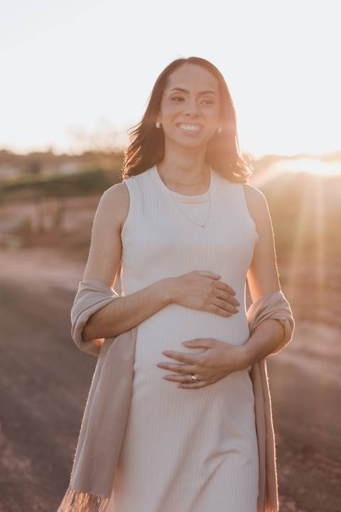 ensaio de gestante no campo com por do sol'