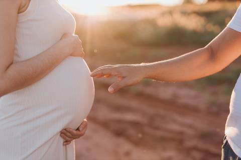 ensaio de gestante no campo com por do sol'