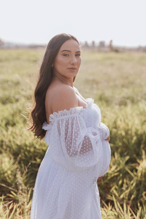 ensaio de gestante no campo com por do sol'