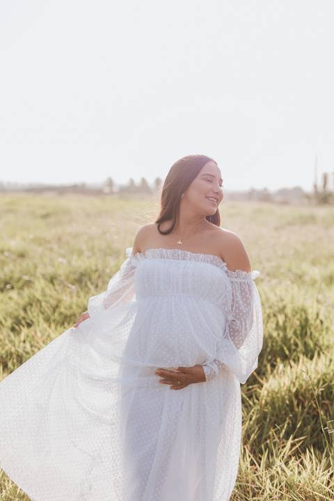 ensaio de gestante no campo com por do sol'