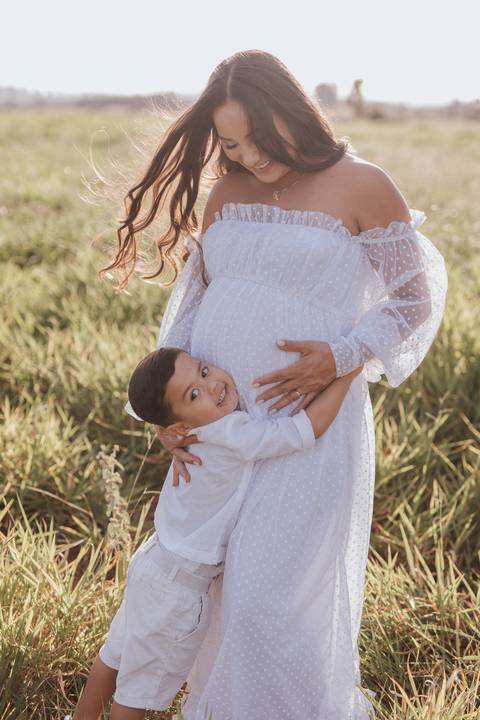 ensaio de gestante no campo com por do sol'