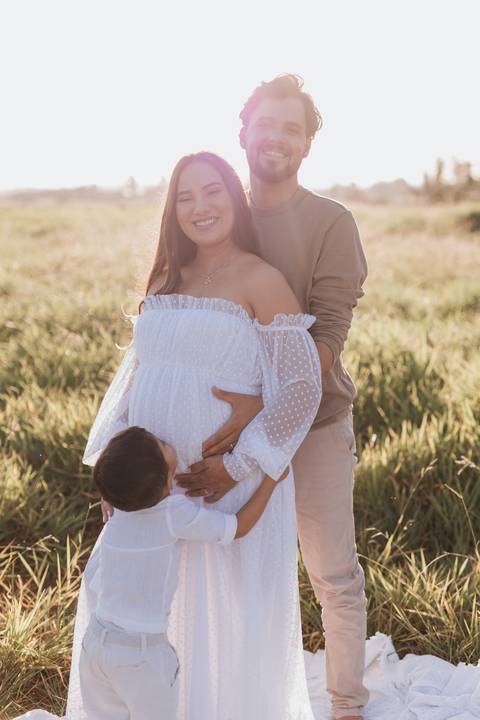 ensaio de gestante no campo com por do sol'