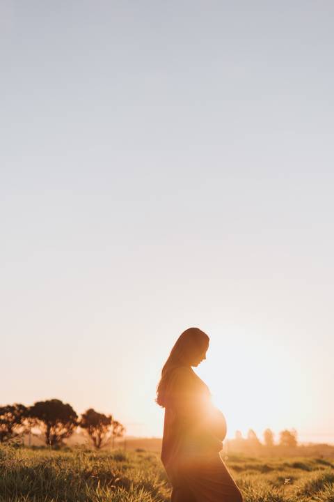 ensaio de gestante no campo com por do sol'