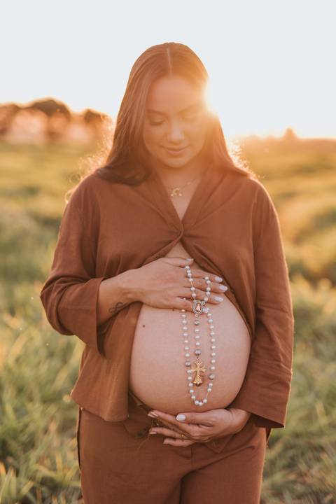ensaio de gestante no campo com por do sol'