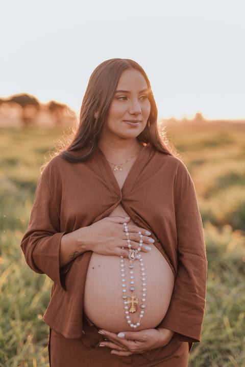 ensaio de gestante no campo com por do sol'