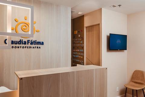 Detalhe de arquitetura de clínica odontológica de luxo, com foco na iluminação técnica e ergonomia do espaço de atendimento.'