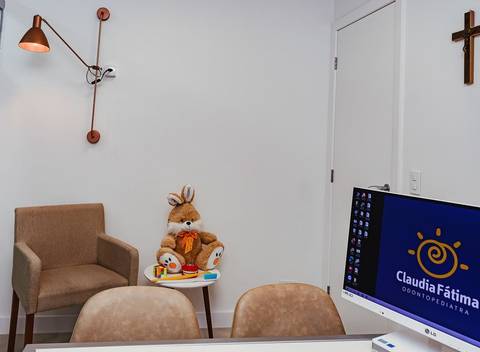 Detalhe de arquitetura de clínica odontológica de luxo, com foco na iluminação técnica e ergonomia do espaço de atendimento.'