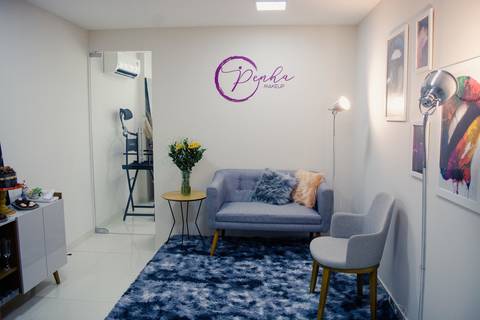 Detalhe de decoração de ateliê de maquiagem em Niterói, com poltrona moderna, tapete de pelúcia e ambiente aconchegante para noivas.'