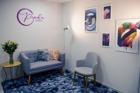 Detalhe de decoração de ateliê de maquiagem em Niterói, com poltrona moderna, tapete de pelúcia e ambiente aconchegante para noivas.'