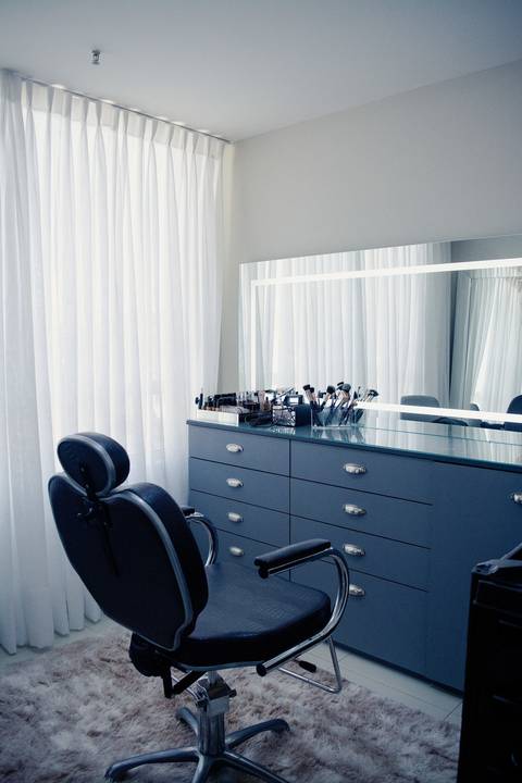 Fotografia de interiores comerciais em Niterói: bancada de maquiagem iluminada com espelho camarim e cadeiras profissionais.'