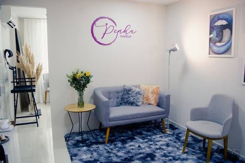 Detalhe de decoração de ateliê de maquiagem em Niterói, com poltrona moderna, tapete de pelúcia e ambiente aconchegante para noivas.'