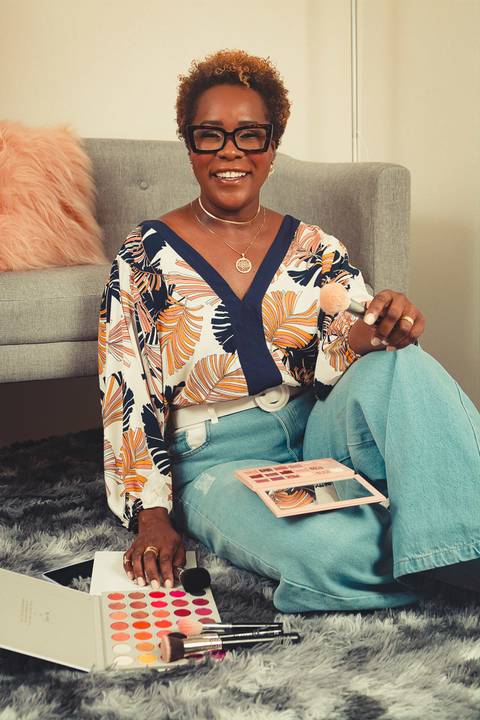 Close da maquiadora Ipenha segurando pincéis profissionais em ensaio de marca pessoal em Niterói.'