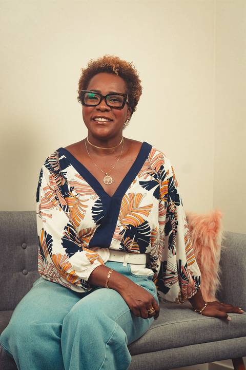 Retrato profissional da maquiadora Ipenha em seu ateliê em Niterói, transmitindo simpatia e autoridade.'