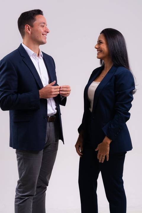 ensaio em estúdio de dois advogados para uso das imagens em site. Os advogados conversam e riem para a camera.'