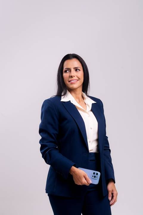 ensaio em estúdio de advogada em no centro de Niterói. A advogada está em pé e olha para o lado esquerdo'