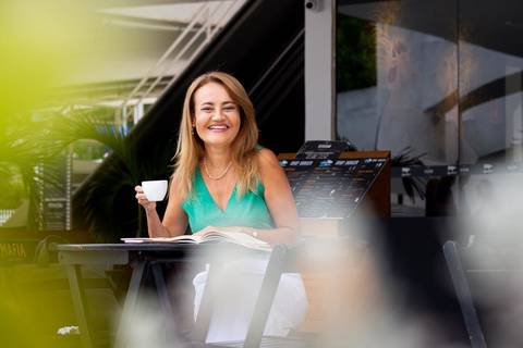 Psicóloga segurando uma xícara, sugerindo o ambiente de conforto e bem-estar oferecido na terapia.'
