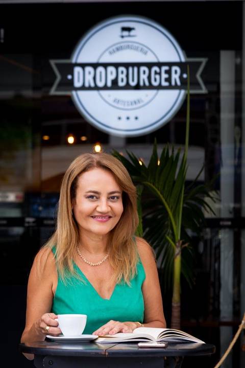 Close-up de psicóloga com foco no olhar e sorriso empático. Transmite conexão direta e prontidão para a escuta ativa.'