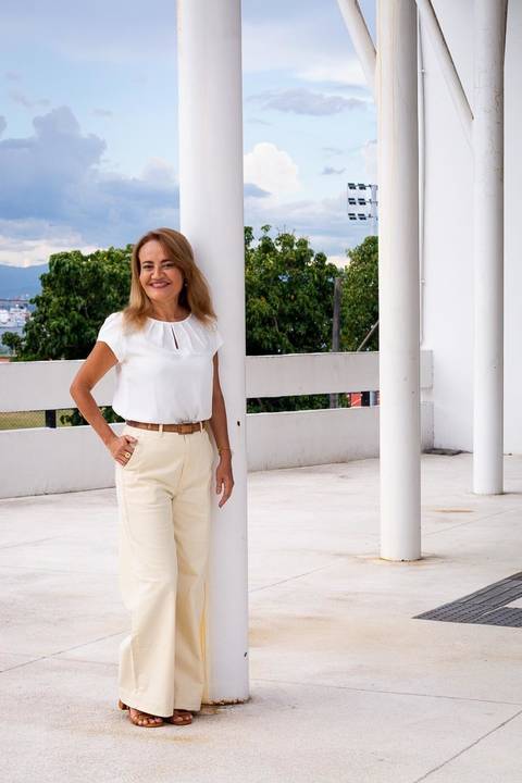 Retrato de psicóloga sorrindo em ambiente externo. A imagem transmite leveza e confiança profissional, resultado de uma direção atenta.'
