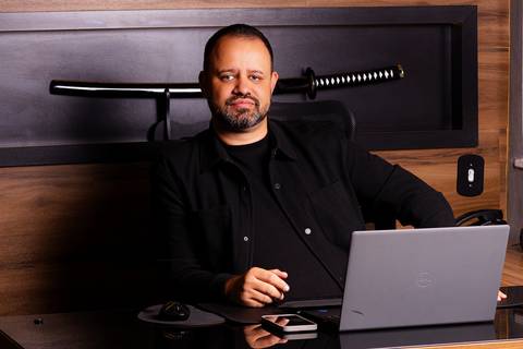 Foto profissional de engenheiro em seu ambiente de trabalho. A postura descontraída, mas assertiva, humaniza a liderança e é perfeita para sites e Landing Pages que buscam conexão.'