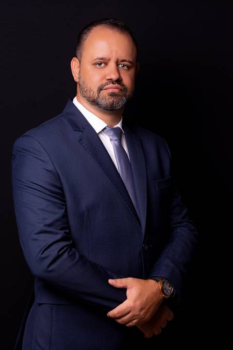 Retrato corporativo masculino com terno e gravata. Uma imagem clássica e impactante, ideal para donos de escritórios que buscam transmitir seriedade e solidez absoluta.'