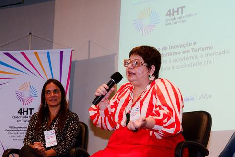Close profissional de palestrante durante evento de inovação e turismo no Rio de Janeiro.'