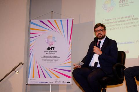Close profissional de palestrante durante evento de inovação e turismo no Rio de Janeiro.'