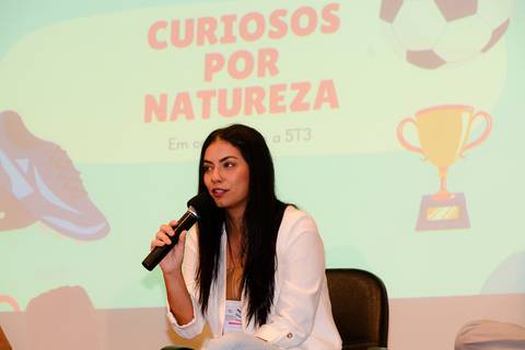 Close profissional de palestrante durante evento de inovação e turismo no Rio de Janeiro.'