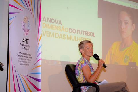 Close profissional de palestrante durante evento de inovação e turismo no Rio de Janeiro.'