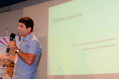 Close profissional de palestrante durante evento de inovação e turismo no Rio de Janeiro.'