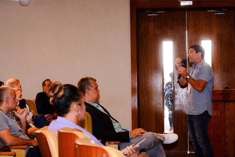 Fotógrafo de eventos no RJ registrando interação entre palestrantes e sociedade civil em congresso.'