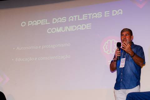 Close profissional de palestrante durante evento de inovação e turismo no Rio de Janeiro.'