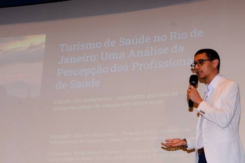 Close profissional de palestrante durante evento de inovação e turismo no Rio de Janeiro.'