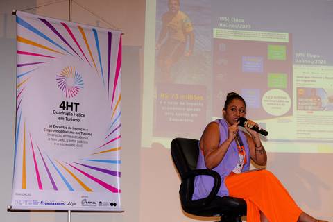 Close profissional de palestrante durante evento de inovação e turismo no Rio de Janeiro.'