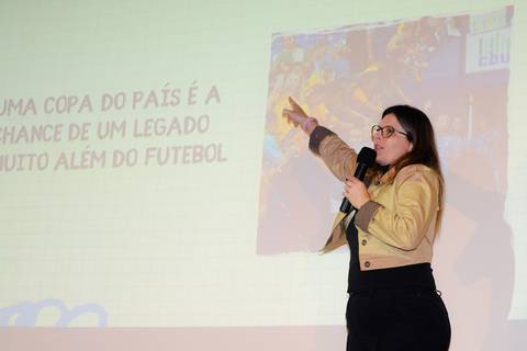 Close profissional de palestrante durante evento de inovação e turismo no Rio de Janeiro.'