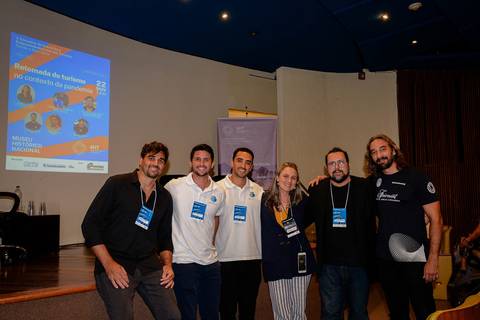 Interação e networking entre empresários e pesquisadores em evento de turismo responsável no Museu Histórico Nacional.'
