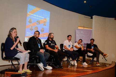 Registro profissional de conferência sobre transformação digital no turismo, destacando palestrantes e apresentação visual.'