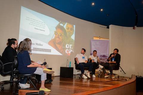 Registro profissional de conferência sobre transformação digital no turismo, destacando palestrantes e apresentação visual.'