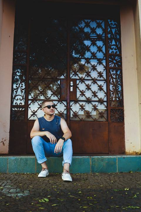 Modelo olhando para o lado vestindo regata e calça Jeans'