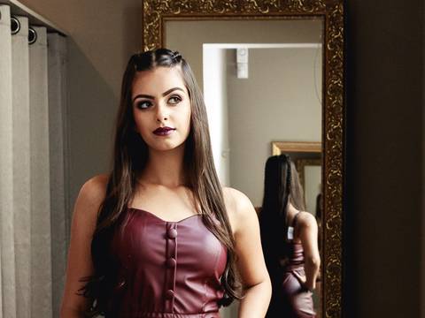 Debutante olhando para o espelho durante ensaio foto gráfio vestindo um look incrível para fotografias'