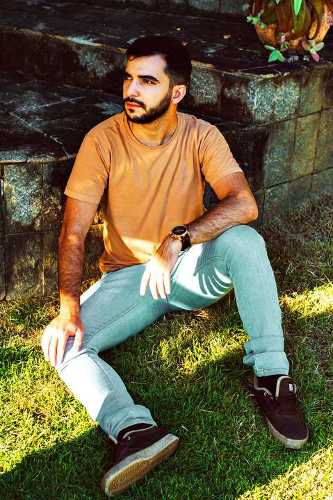 Ensaio masculino externo com livros e violão Agência Cricaré'
