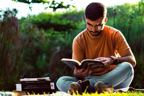 Ensaio masculino externo com livros e violão Agência Cricaré'