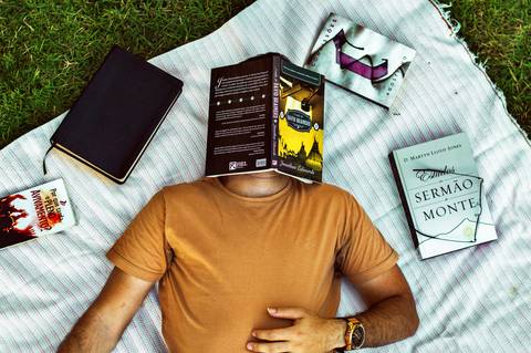 Ensaio masculino externo com livros e violão Agência Cricaré'