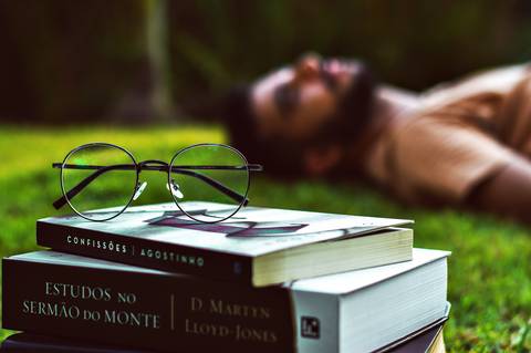 Ensaio masculino externo com livros e violão Agência Cricaré'