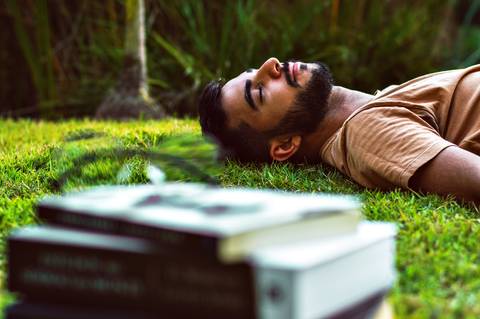 Ensaio masculino externo com livros e violão Agência Cricaré'