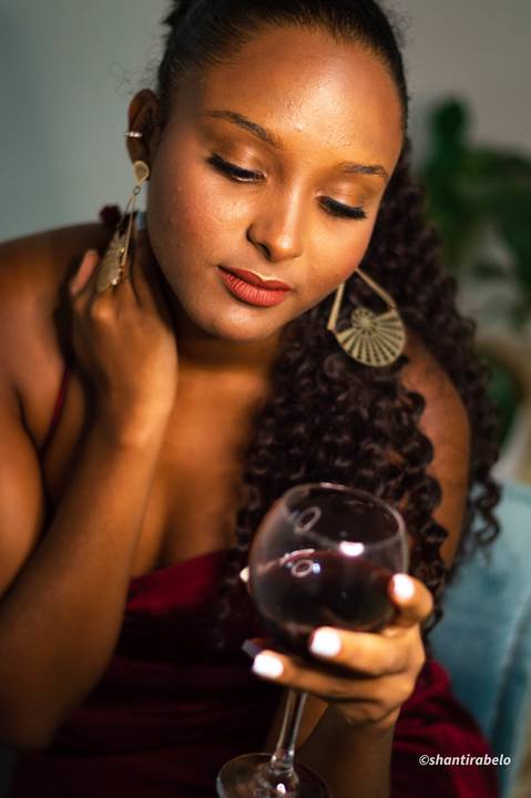 Ensaio feminino interno, vestido vermelho, taça de vinho, Agência Cricaré, Caratinga (MG).'