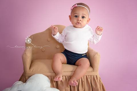 Sessão de acompanhamento da Graziella com 6 meses, no fundo rosa, sentada no sofázinho com nuvem sorridente. Ensaio realizado em Barra Mansa - Newborn Acompanhamento Gestante e Família - Volta Redonda'