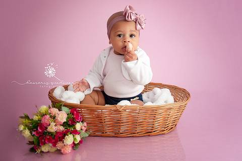 Sessão de acompanhamento da Graziella com 6 meses, no fundo rosa, sentada no cestinho com flores. Ensaio realizado em Barra Mansa - Newborn Acompanhamento Gestante e Família - Volta Redonda'