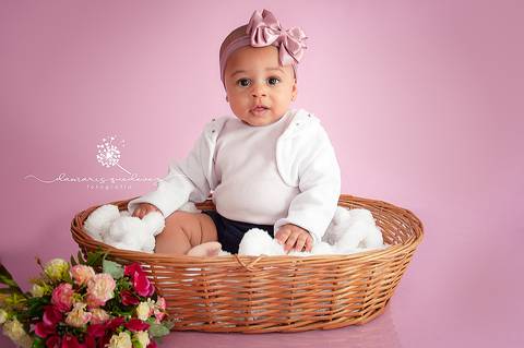 Sessão de acompanhamento da Graziella com 6 meses, no fundo rosa, sentada no cestinho com flores. Ensaio realizado em Barra Mansa - Newborn Acompanhamento Gestante e Família - Volta Redonda'